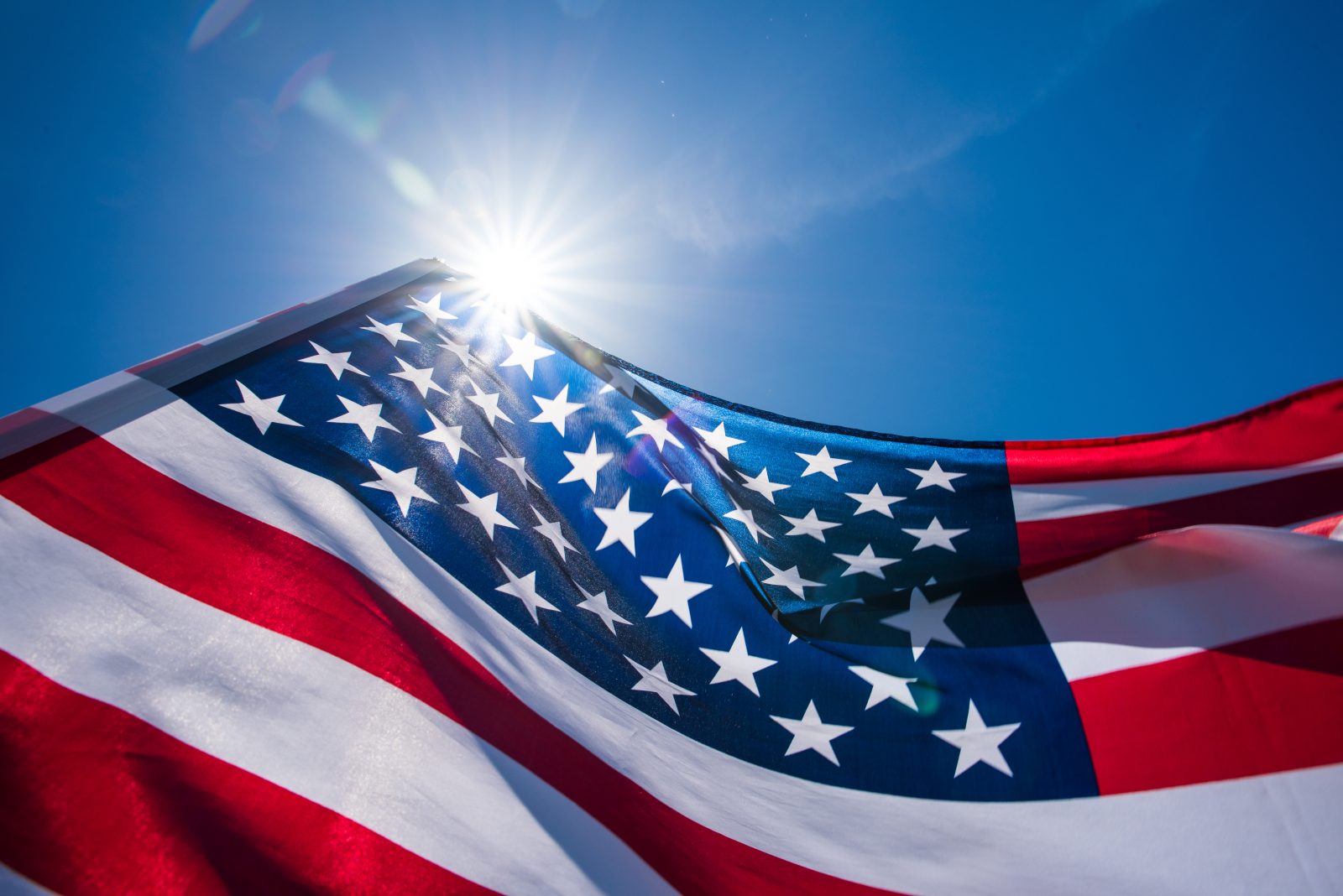 Close up United States of America flag on the blue sky background.