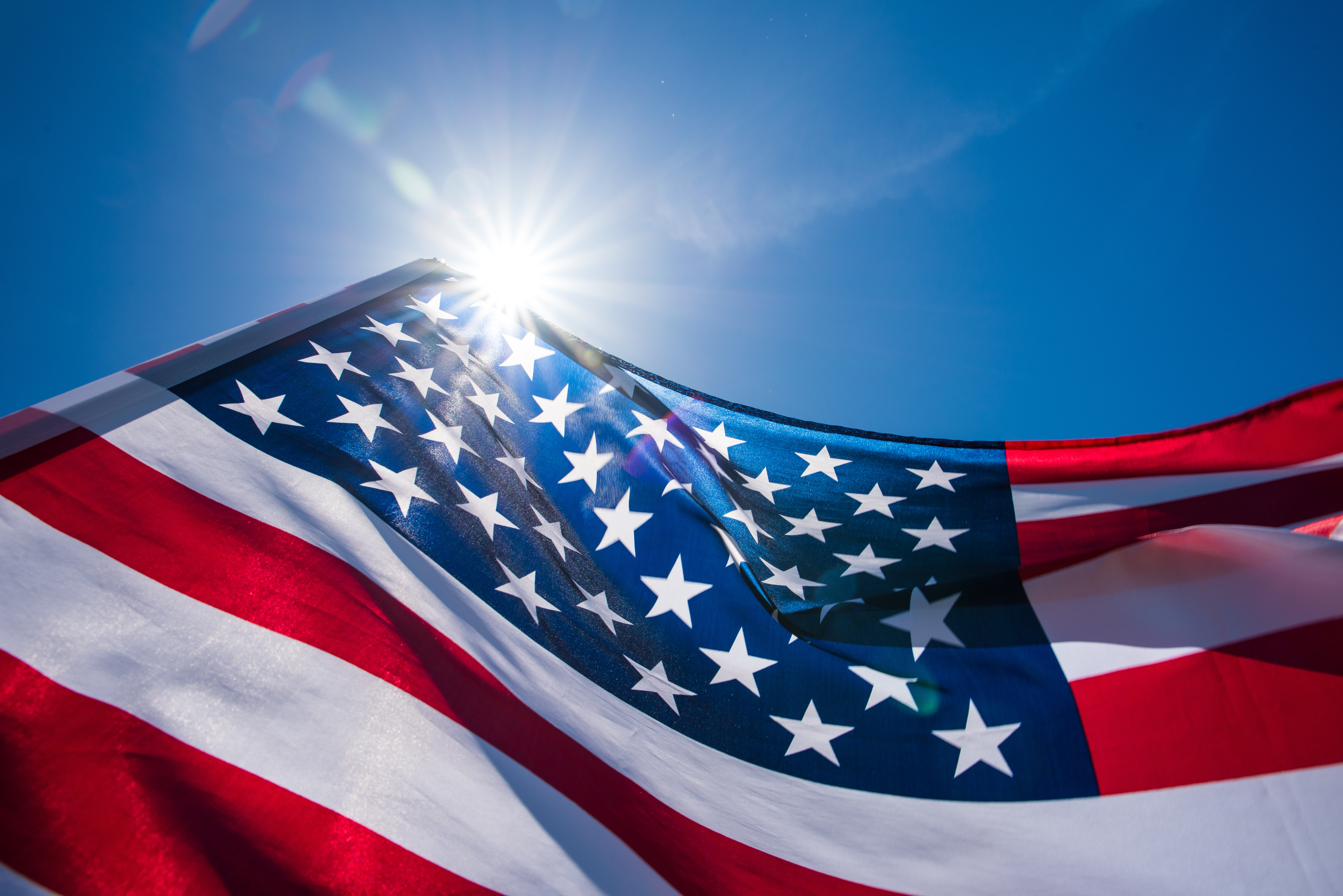 Close up United States of America flag on the blue sky background.
