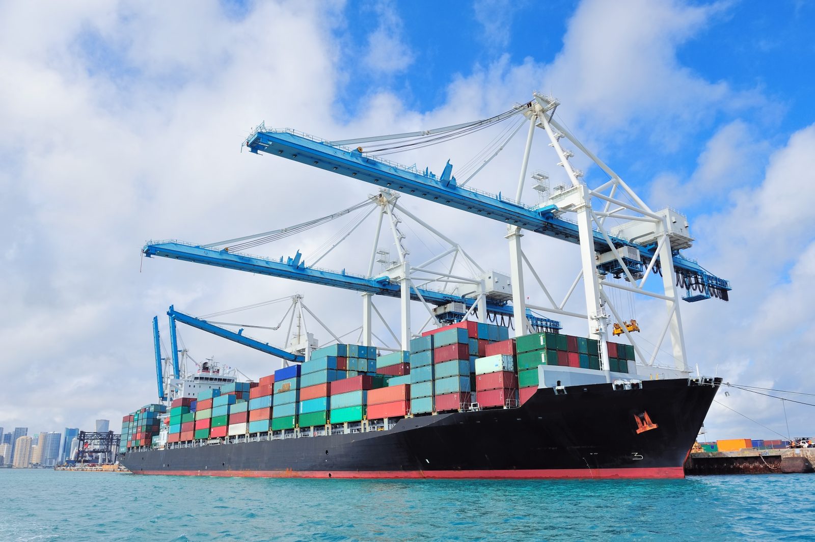 Cargo Ship At Miami Harbor With Crane And Blue Sky