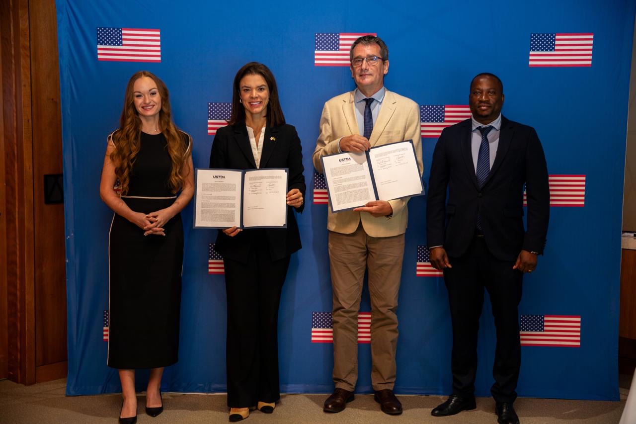 Group photo holding the signed grant documents following the ceremony.