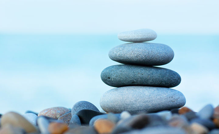 Four rocks stacked on a beach