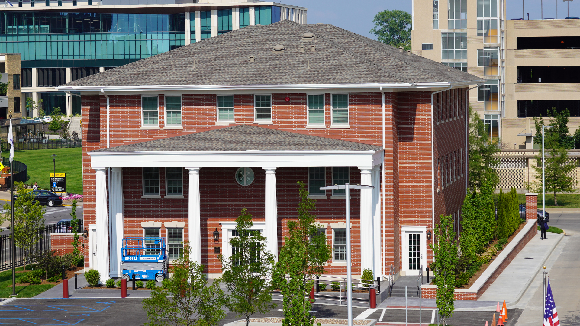 Photo; three story house done in red brick with a white porch