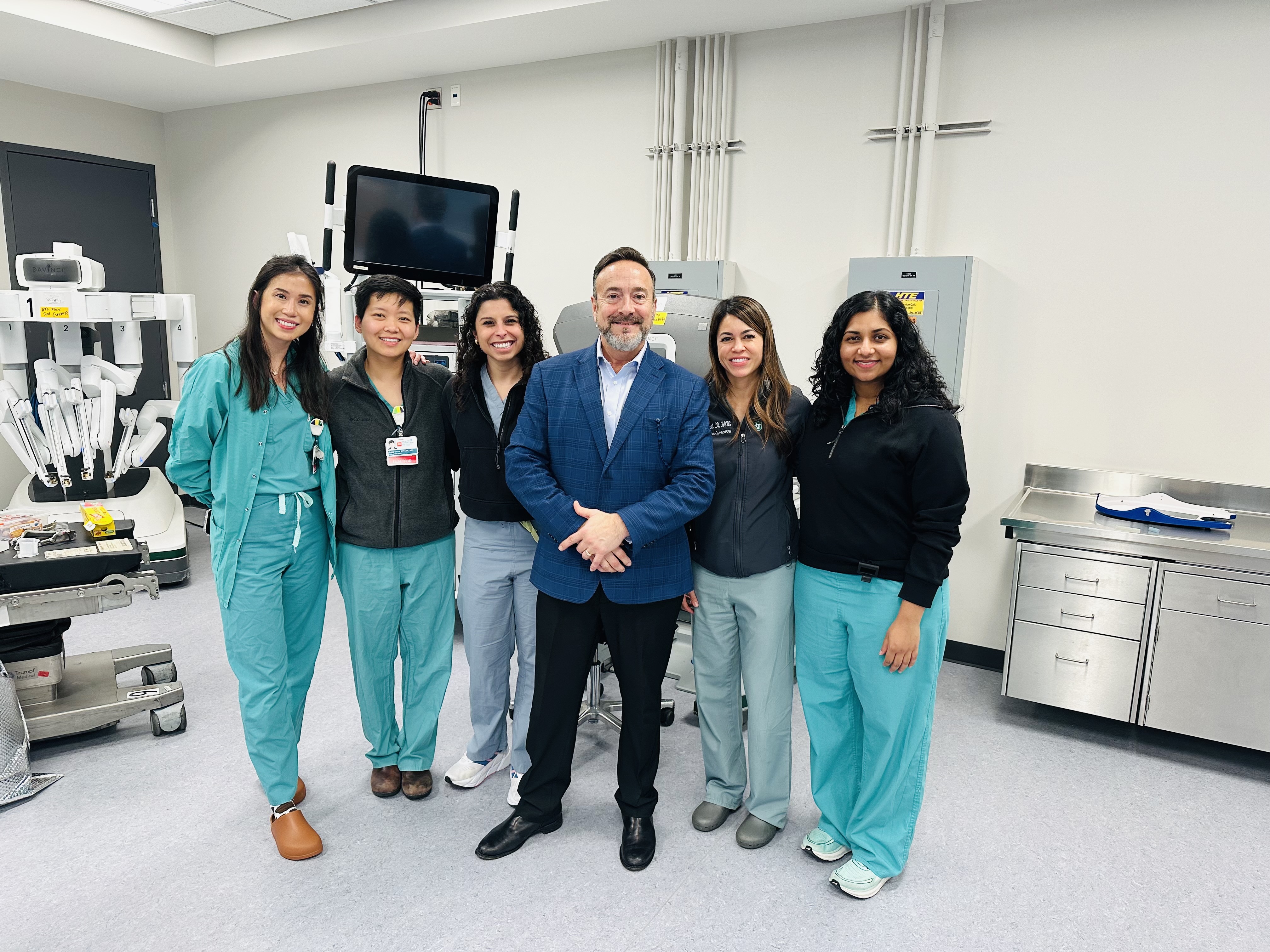 Six New Orleans VA staff in the Minimally Invasive Gynecology Surgery program stand posing and smiling.
