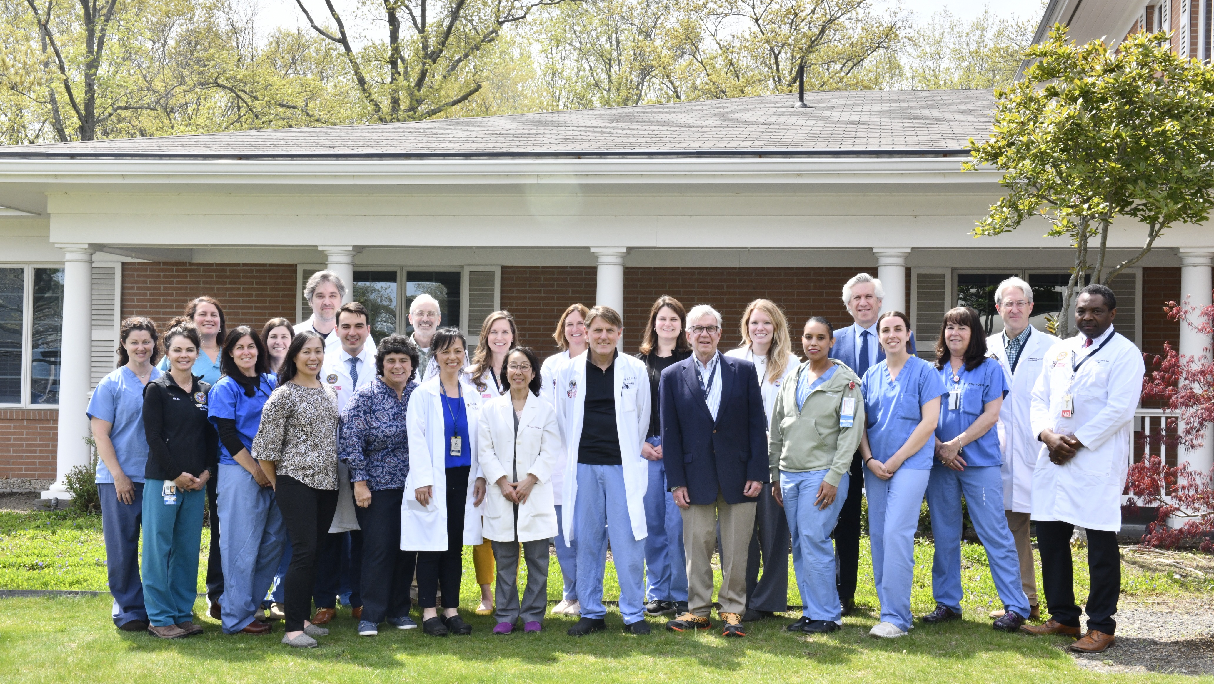 Group of doctors and nurses standing in front of a building.