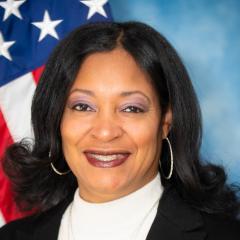 Black woman standing in front of a flag
