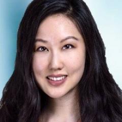 Portrait of a woman with long black hair smiling.