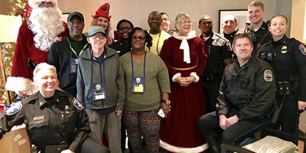 Santa, Mrs. Claus and the City of Charleston Police Department stand with Fisher House families during a special donation for Veterans. 