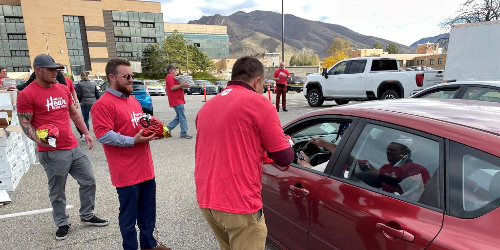 Man handing ham to person in car.