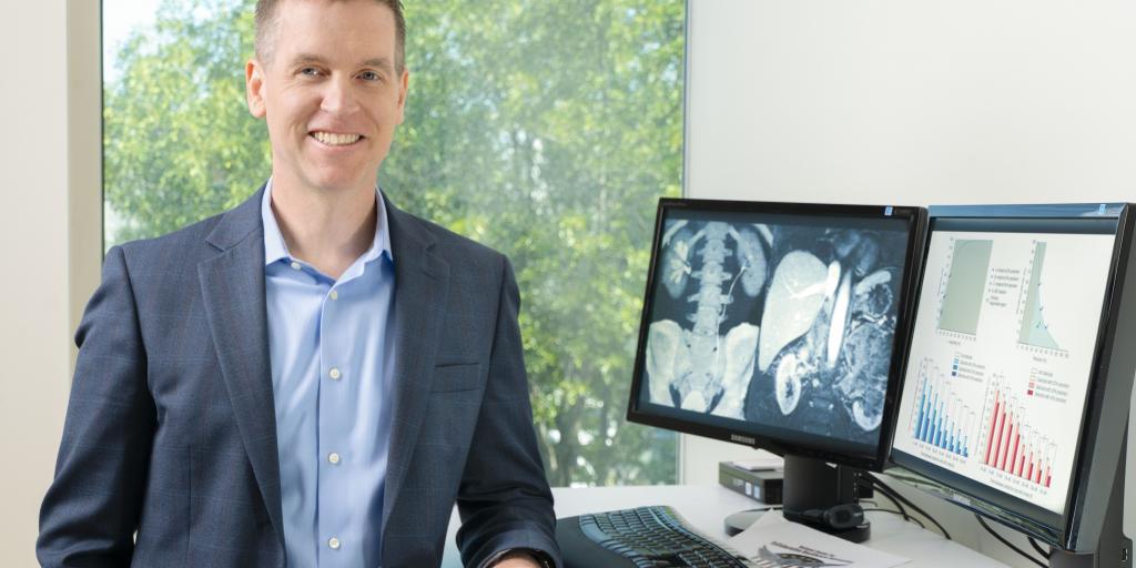 Dr. Thomas Osborne standing next to a computer