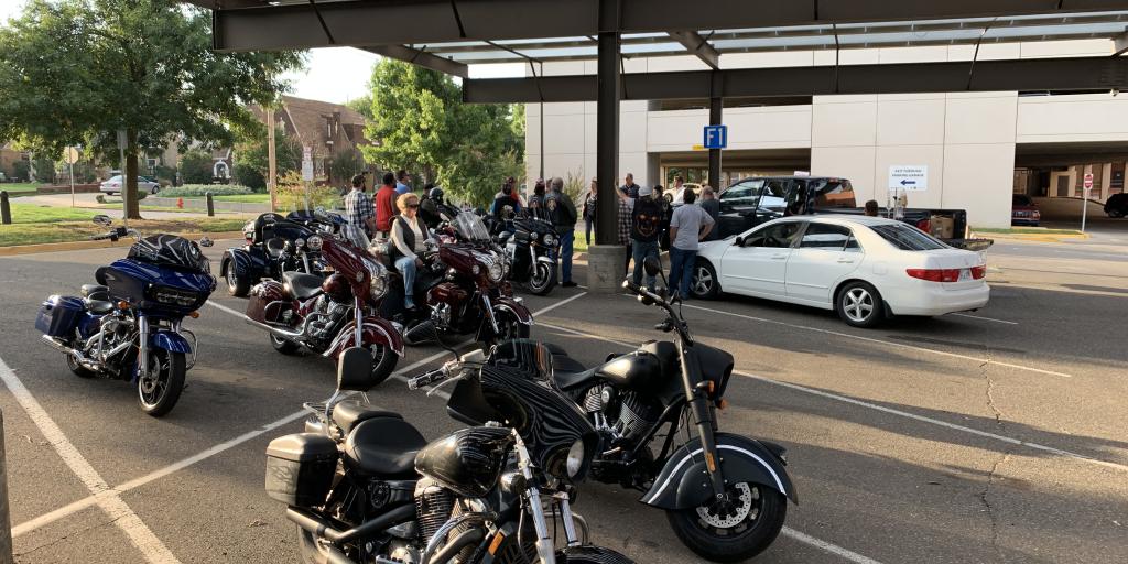 Motorcycles parked in front of a Veterans gathering