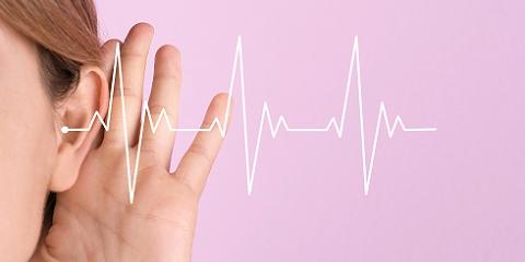 Young woman with symptom of hearing loss on color background