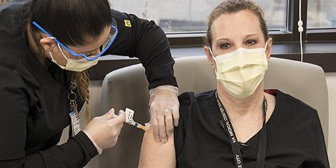 A VA nurse gets a COVID-19 vaccine