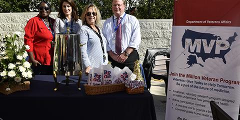 (From Left to Right) Teresa Mitchell, Courtney Harrington, Dana Rosson and Mark Hamner, MD, hand out free popcorn and lemonade to staff and visitors to celebrate their latest Million Veteran Program milestone. Photo by Scott Pauley.