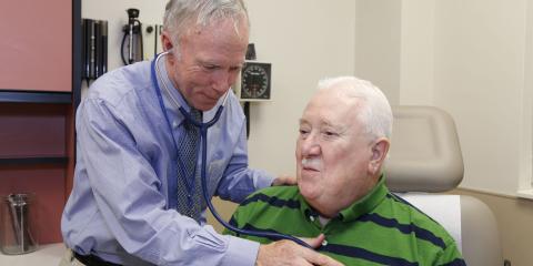 Dr. Daniel Birchmore checks a Veteran's vitals during an appointment.