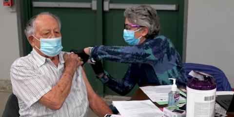 A Veteran receives a vaccine from a health care worker