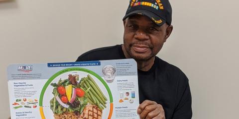 Army Veteran holds VA healthy plate poster