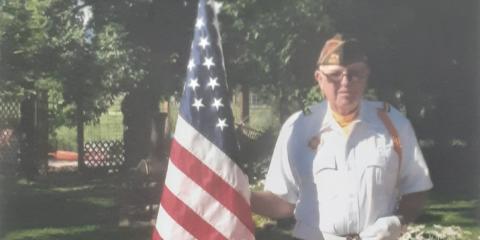 Ben Reed stands with a flag as a part of the Honor Guard