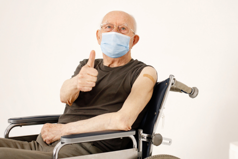 A man in a wheelchair giving a thumbs-up sign