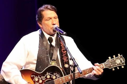 Air Force Veteran Joe Ramage plays an acoustic guitar on stage at the Veterans Creative Arts Festival in Indianapolis, Ind., May 17, 2025.