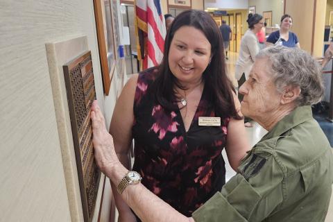 Veteran touches a brass tactile U.S. flag at VA Pittsburgh's H.J. Heinz III campus.