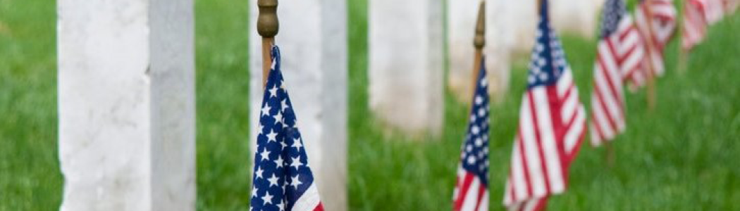 American flags next to headstone.